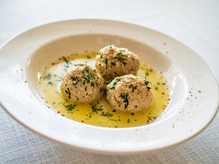 Boiled meatballs in dill sauce on white table
