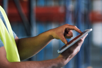 Stay connected, stay safety compliant. Shot of a builder using a digital tablet while working at a...