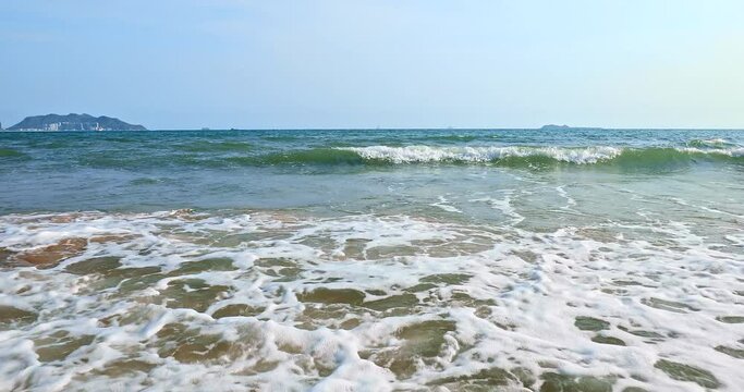 White foam of rolling waves in Sanya, Hainan Island, China. Beautiful seascape. azure sea and blue sky.