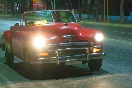 Vintage American car driving at night in Varadero, Cuba