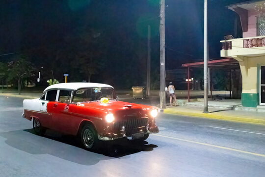 Vintage American car driving at night in Varadero, Cuba