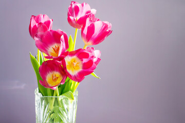 A beautiful bouquet of tulips in a crystal vase. The concept of spring flowers, romance, love.