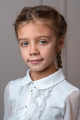 Portrait of cute caucasian kid at home looking to camera. Indoor portrait of eight years old girl