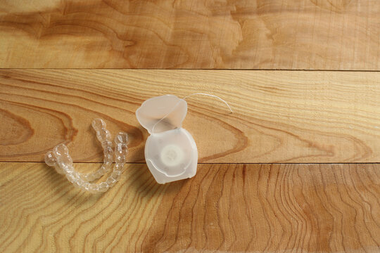 Mouthpiece and dental floss on a wooden table