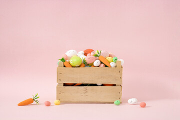 Vintage Easter basket full of painted eggs. Creative spring concept on pastel pink background.