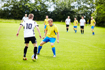 Playing good defense. A group of soccer players in the middle of a game. - Powered by Adobe