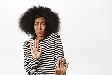 Portrait of Black woman staring with aversion and dislike, cringe from smth bad, awful disgusting...