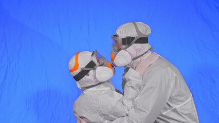 Doctor man and woman in protective costume suit, gas protect medical spray paint mask. Love couple kiss and hug, health worker in respirator. Health virus protection coronavirus epidemic covid-19.
