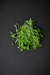 Top view of a threads of a micro greens arranged on a black background.