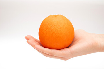 Ripe whole orange fruit on the hand