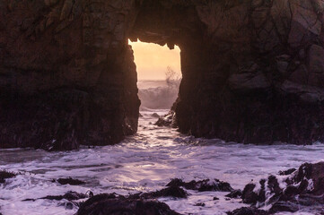 A sunset sky peeping thought the keyhole arch at Pfeiffer Beach, near Big Sur California.