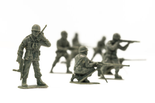 Plastic toy soldiers are arranged in a conflict situation and set against a white background. 
