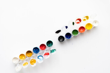 Flat composition a set of multi-colored paints in jars. Space for the text.