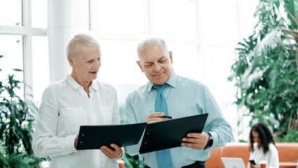Obraz premium business colleagues discussing business documents standing in the office lobby .