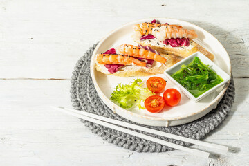 Open sandwiches with boiled shrimps, cream cheese, salad leaves, and Chuka salad. Seafood