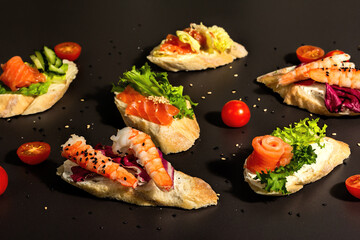 Assorted open sandwiches with salted salmon, shrimps, cream cheese, salad leaves and cucumber