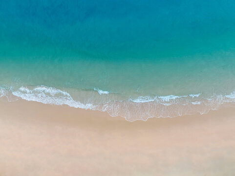 Aerial view Perspective of Waves and Beach from top view. Blue water background by drone. © SASITHORN