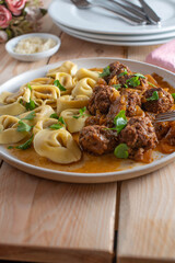 Rustic pasta dish with meatballs, cabbage and sauce