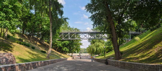 Descent to the Sozh River and a pedestrian bridge on the territory of the palace and park ensemble of the city of Gomel in the Republic of Belarus