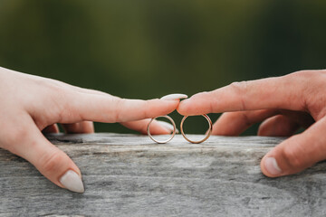 Hands of brides holding wedding rings. Wedding rings and fingers.