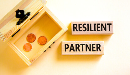 Resilient partner symbol. Concept words Resilient partner on wooden blocks on a beautiful white background. Wooden chest with coins. Business resilience resilient partner concept, copy space.