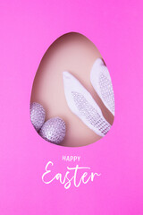 Happy Easter greeting with egg cut out of paper and bunny ears with eggs. Easter holiday concept.