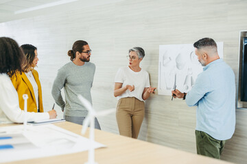 Group of designers working on a wind turbine project in an office