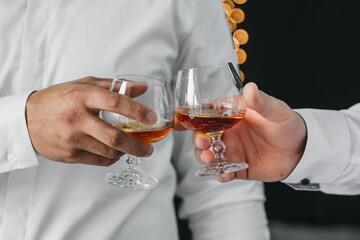 men knocking glasses. Booze. Alcohol. Two glasses.