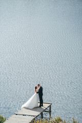 Silhouettes of lovers near the water. Brides