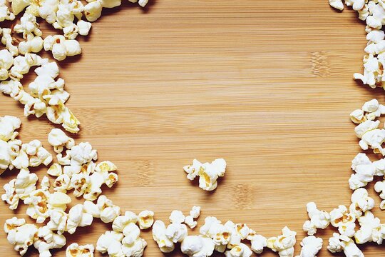 Popcorn on a plank background with empty space to insert text.
