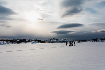 ślady na śniegu, turyści zwiedzają piękne Lofoty w Norwegii, ośnieżone góry i zamarznięte...