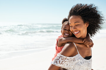 Happy mother giving daughter piggyback ride at beach - Powered by Adobe
