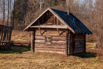 Obraz premium Early spring sky over village with small wood log local house and low fence. Travelling on the suburb roads. People living