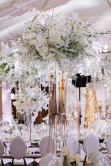 Wedding table decor in white green tones. Wedding table set up in boho style with pampas grass and greenery, soft focus.