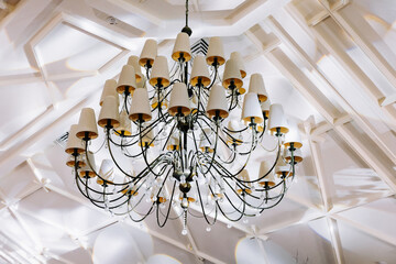 Chandelier on a white ceiling. Wedding decor in the style of boho.