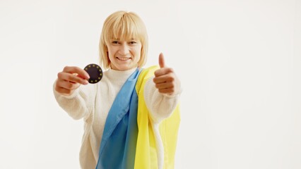Smiling Woman with ukrainian flag showing a pin of Europe and thumbs up. Space. High quality photo