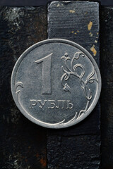 Russian coin denominated 1 ruble. shines on a scratched metal surface. close-up. translation of the...