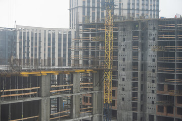 Large construction site including several cranes working on a building complex,