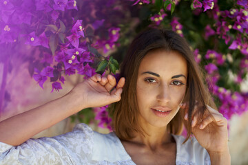 Beauty portrait close up face young attractive woman in spring garden with pink flowers