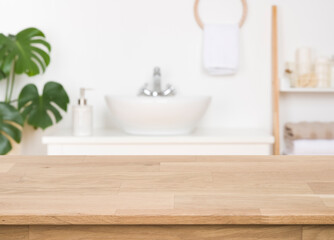 Fototapeta na wymiar Wooden counter on blurred bathroom background, design key visual layout
