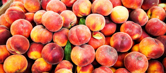 Heap of fresh ripe peaches at local farmers market