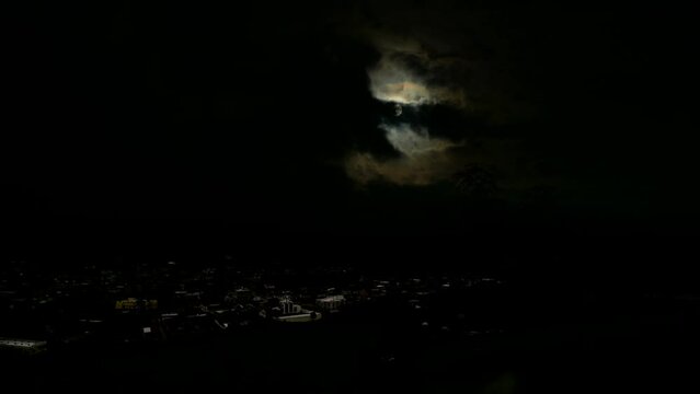 night moon time lapse. Aerial view of moon and village.
