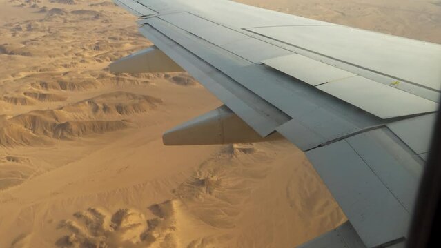 Plane comes in for a landing in the desert, the view from the window on the wing of the airplane and flaps, the fall and plane crash.