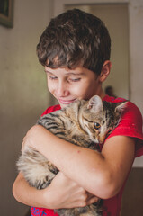 Portrait of boy hugging tabby cat
