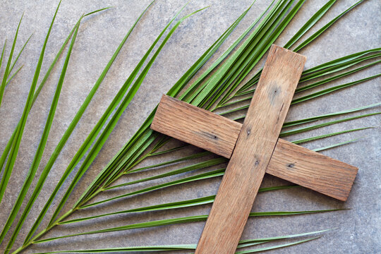 Easter wooden cross with palm branch, palm sunday religious concept abstract 