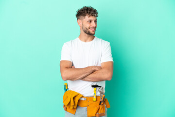 Young electrician blonde man isolated on green background happy and smiling