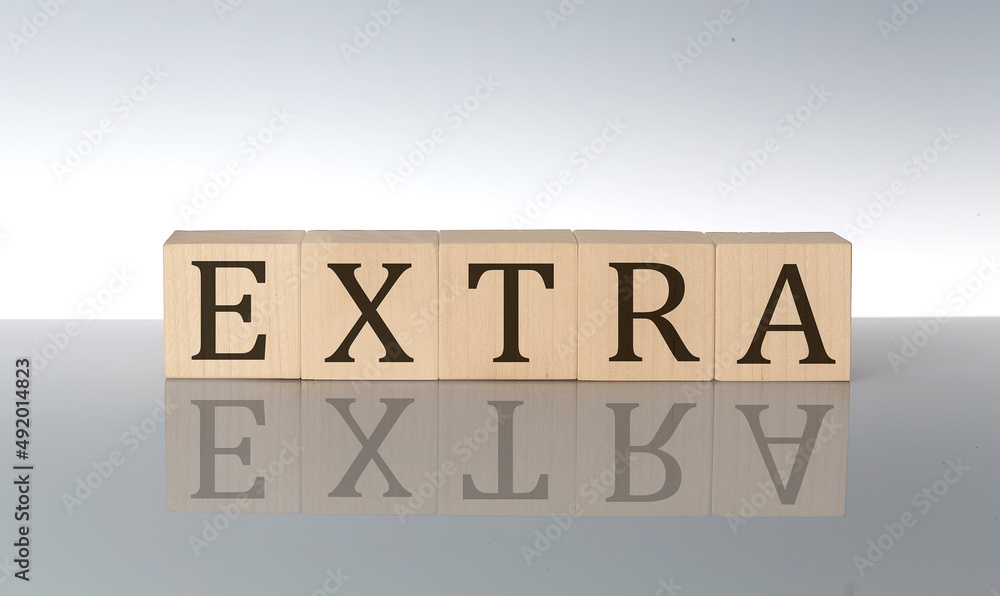 Aufkleber extra word made with building blocks isolated on grey background