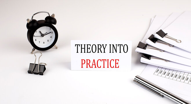 Card with text THEORY INTO PRACTICE on a white background, near office supplies and alarm clock. Business concept.