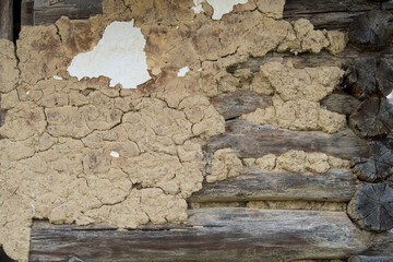 Sunja, Croatia, April 20,2021 : Facade of mud and straw on old wooden house.