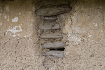 Sunja, Croatia, April 20,2021 : Facade of mud and straw on old wooden house.